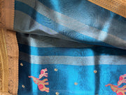 Woman wearing an elegant royal blue tissue silk saree for a celebration